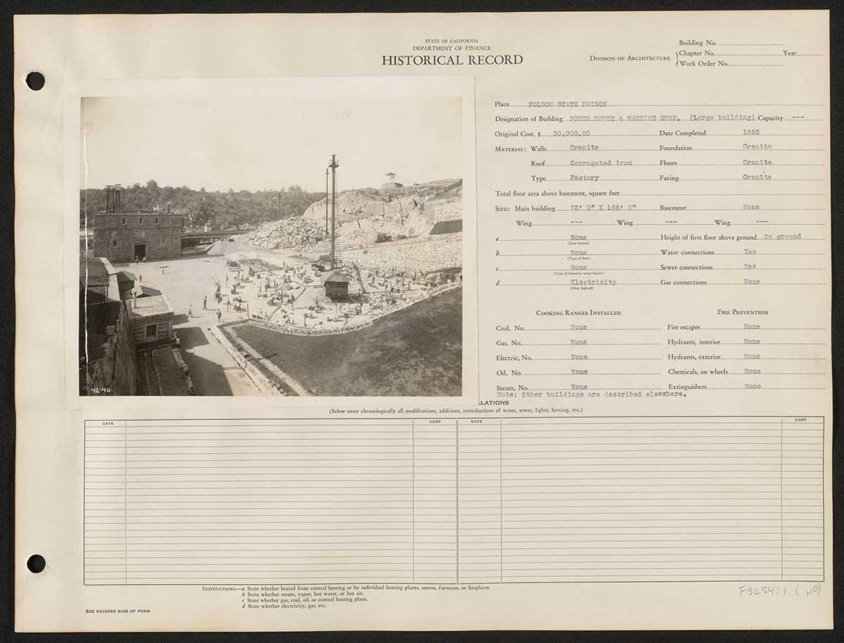 A historical ledger from the California Department of Finance documenting details about the rock house and machine shop at Folsom State Prison. The black-and-white photograph shows a busy scene with numerous prisoners working in an open yard area near a large stone building designated as the rock house and machine shop, completed in 1892 at a cost of $50,000. The structure features granite walls and a corrugated iron roof. The ledger notes the building's dimensions (72 ft x 166 ft) and various utility connections, such as water and sewer, though it lacks gas and electric connections.